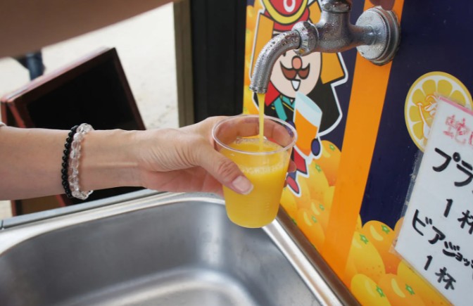Fresh mikan juice poured from a citrus tap in Matsuyama